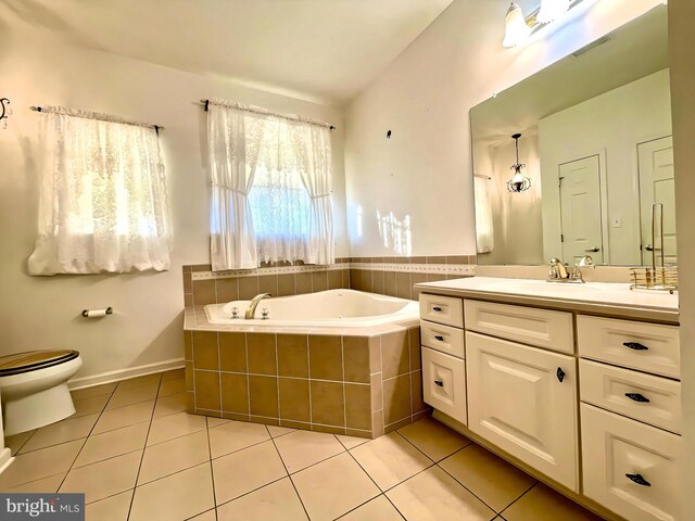 bathroom featuring toilet, vanity, tiled tub, and tile patterned floors