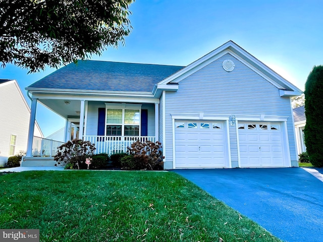 view of front of property featuring a front yard, a porch, and a garage