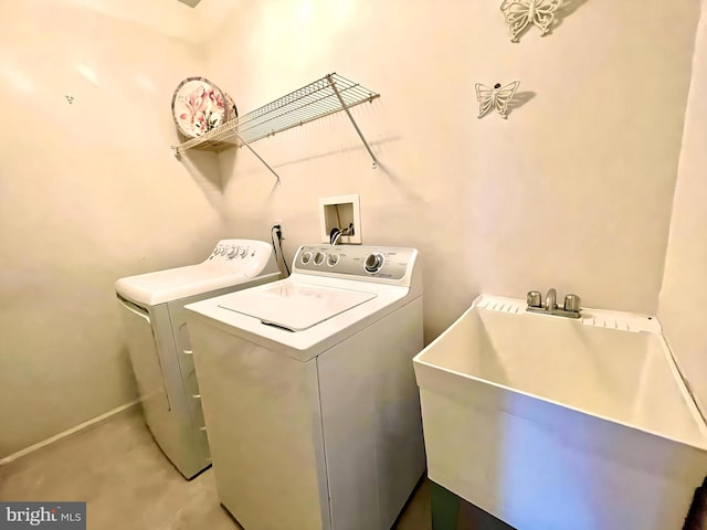 clothes washing area with independent washer and dryer and sink