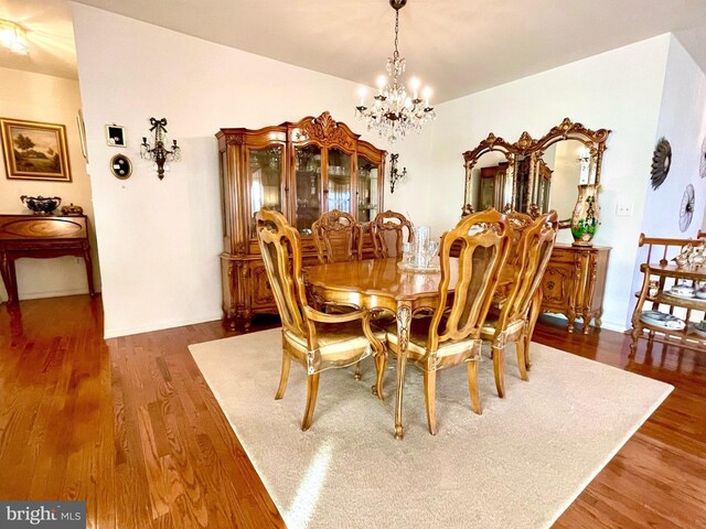 dining area featuring an inviting chandelier and hardwood / wood-style flooring