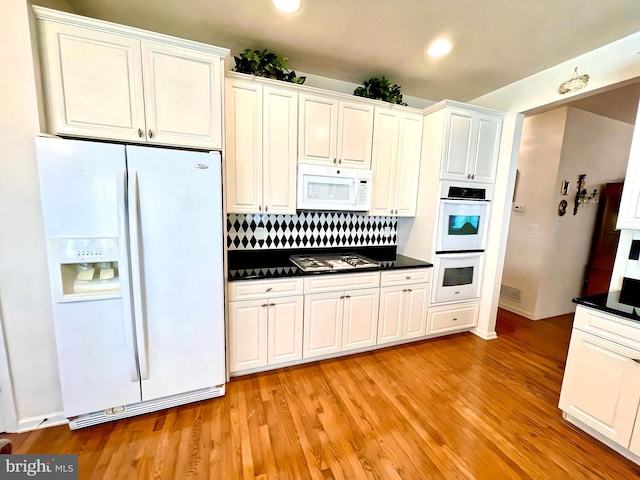 kitchen with white cabinetry, light wood-type flooring, white appliances, and tasteful backsplash