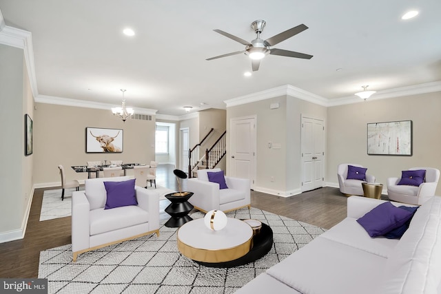 living room with ornamental molding, wood-type flooring, and ceiling fan with notable chandelier