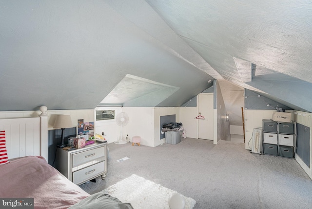 interior space with lofted ceiling, a textured ceiling, and light colored carpet