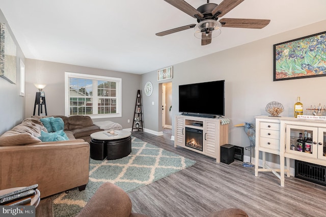 living room featuring wood-type flooring and ceiling fan