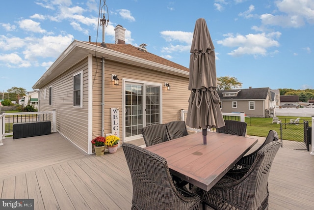 wooden terrace featuring a lawn