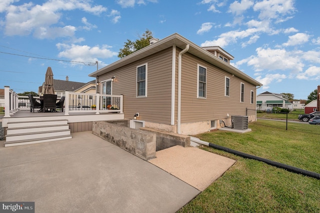 view of home's exterior featuring a deck, a lawn, and central AC unit