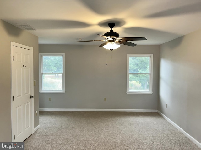 empty room featuring light carpet, a healthy amount of sunlight, and ceiling fan