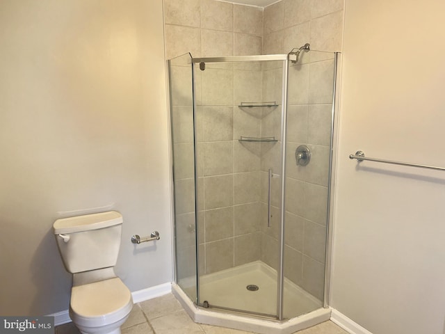 bathroom with toilet, tile patterned floors, and a shower with shower door