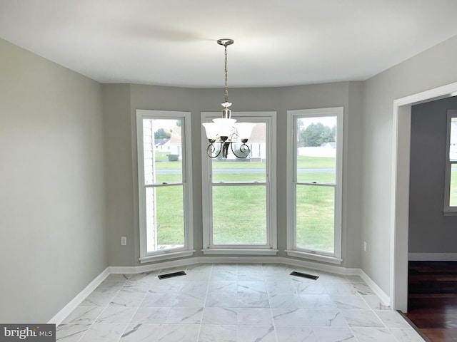 unfurnished dining area with a notable chandelier and plenty of natural light