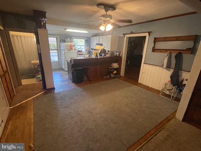 living room featuring ceiling fan, ornamental molding, and dark hardwood / wood-style flooring