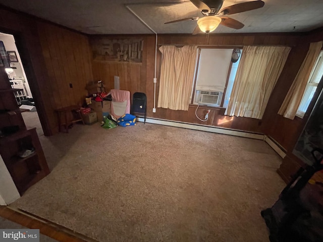 interior space with cooling unit, wood walls, carpet, and ceiling fan