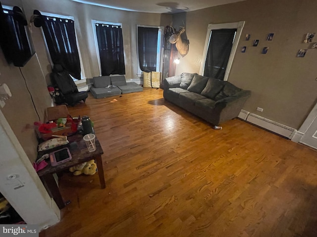 living room featuring baseboard heating and wood-type flooring