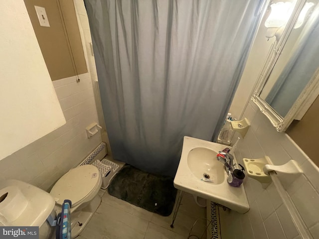 bathroom with toilet, tile patterned flooring, sink, a shower with shower curtain, and tile walls