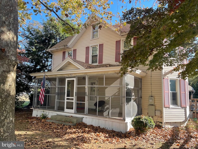 back of property with a sunroom