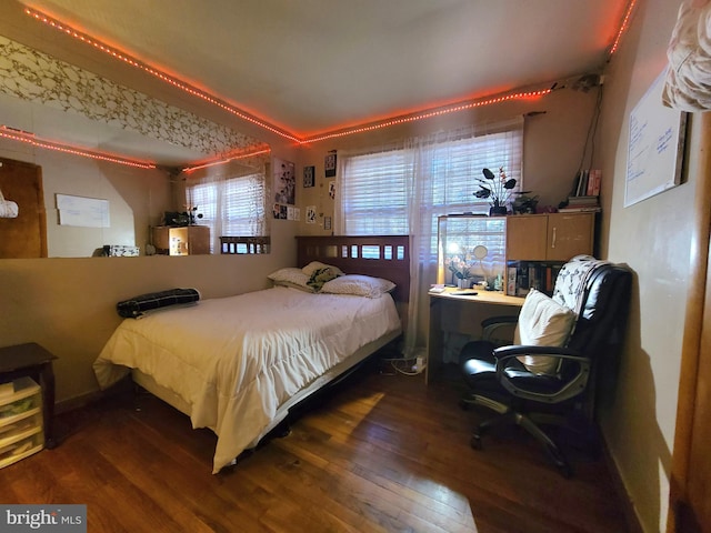 bedroom featuring multiple windows and dark hardwood / wood-style flooring