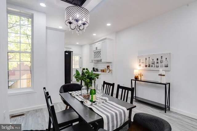 dining space with a chandelier, light hardwood / wood-style flooring, and a healthy amount of sunlight