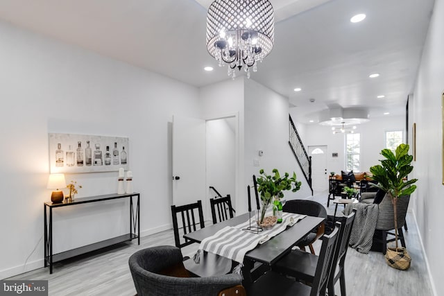 dining space with a notable chandelier and light wood-type flooring