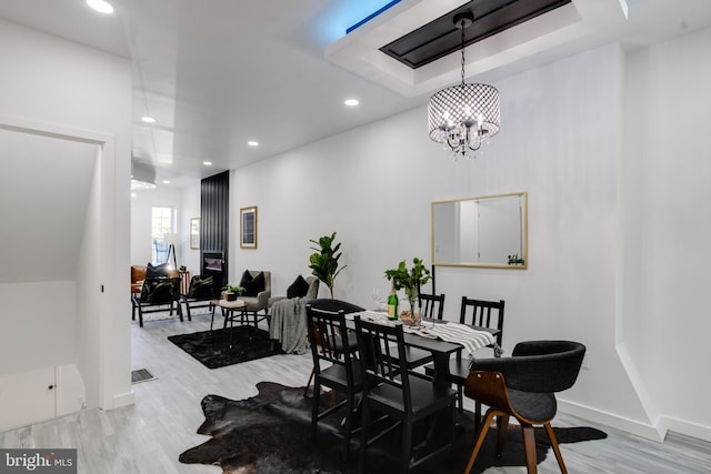 dining space featuring a notable chandelier and light wood-type flooring