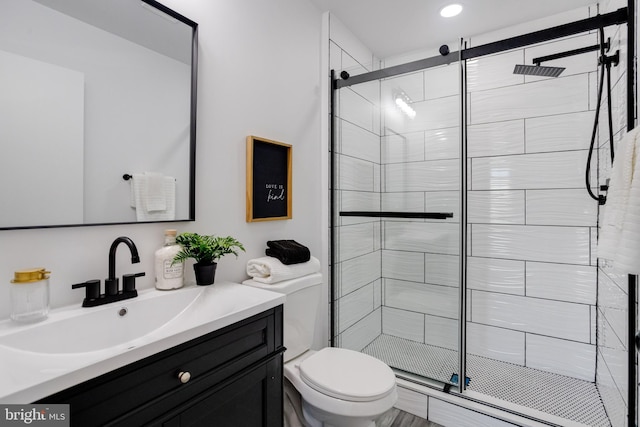 bathroom featuring vanity, toilet, and an enclosed shower