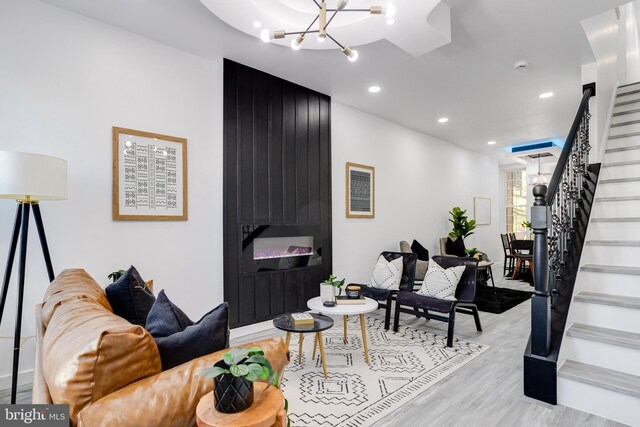 living room featuring a notable chandelier and light hardwood / wood-style flooring