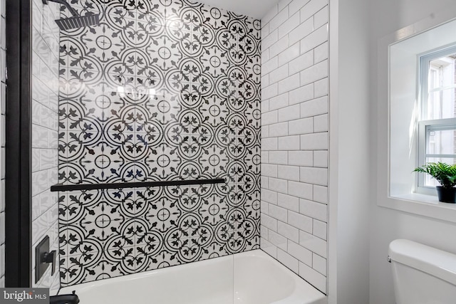 bathroom featuring toilet and tiled shower / bath combo