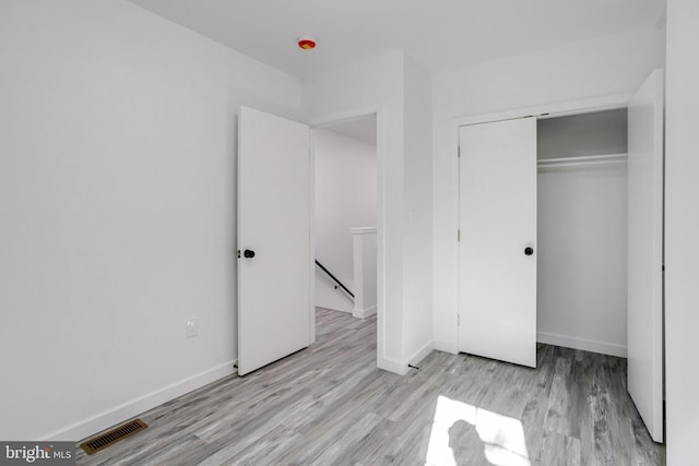 unfurnished bedroom featuring a closet and light wood-type flooring