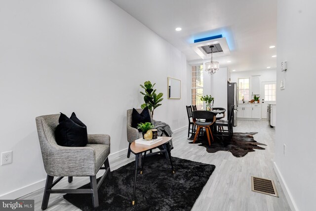 living area featuring light hardwood / wood-style floors and a notable chandelier