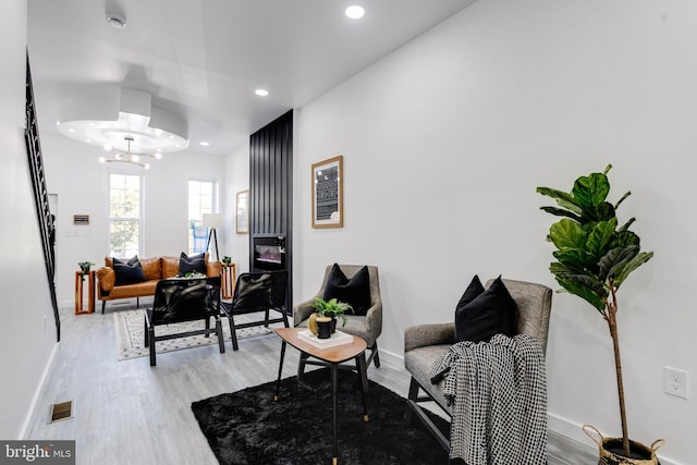 sitting room with light hardwood / wood-style floors and a chandelier