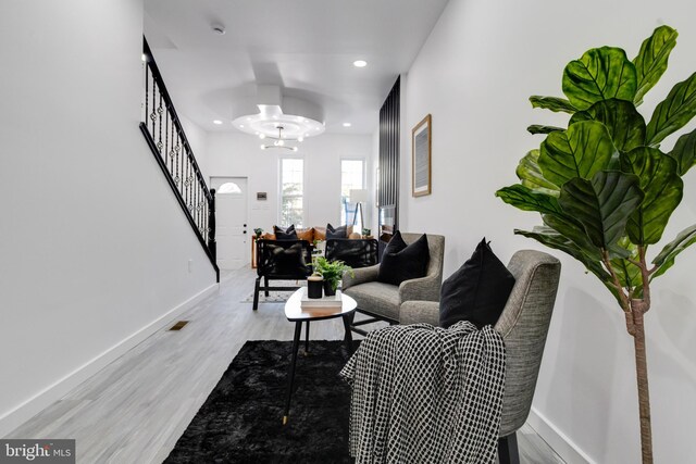 living room with light hardwood / wood-style flooring and a notable chandelier