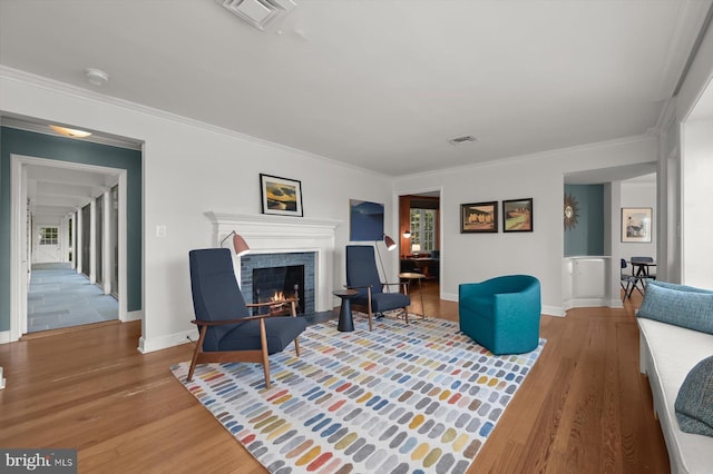 living room featuring hardwood / wood-style flooring, ornamental molding, and plenty of natural light