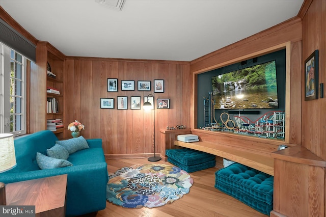 sitting room with wooden walls, hardwood / wood-style floors, and built in features