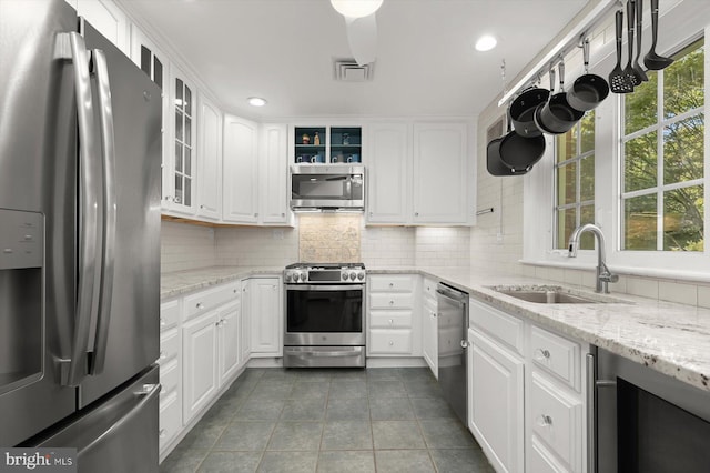 kitchen with white cabinetry, appliances with stainless steel finishes, beverage cooler, and sink