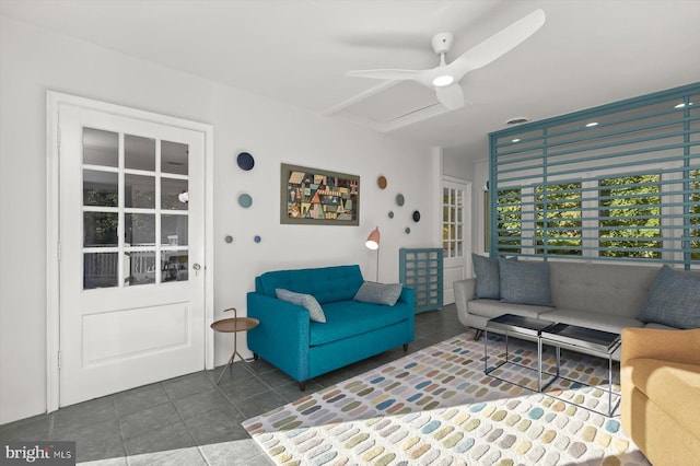 living room with dark tile patterned flooring and ceiling fan