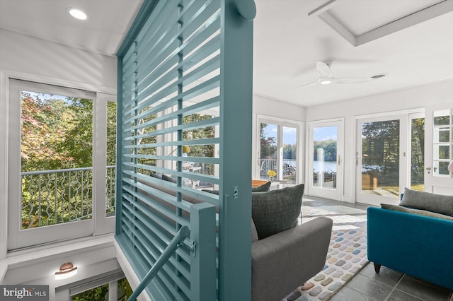 sunroom / solarium with a water view, a wealth of natural light, and ceiling fan