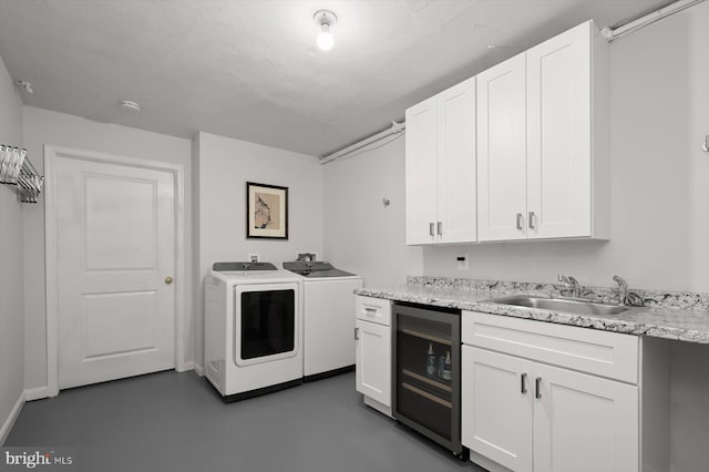 laundry room with sink, a textured ceiling, beverage cooler, and independent washer and dryer