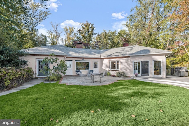 rear view of property with a yard and a patio