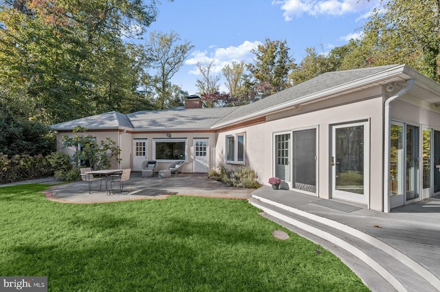 back of property featuring a lawn and a patio