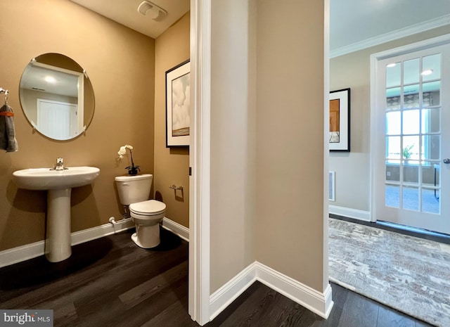 bathroom featuring sink, crown molding, hardwood / wood-style flooring, and toilet