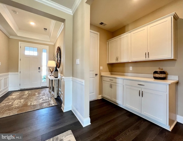 entryway with ornamental molding, dark hardwood / wood-style floors, and a tray ceiling