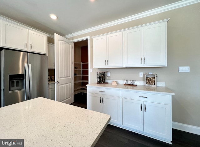 kitchen featuring white cabinetry, light stone counters, dark hardwood / wood-style floors, and stainless steel fridge