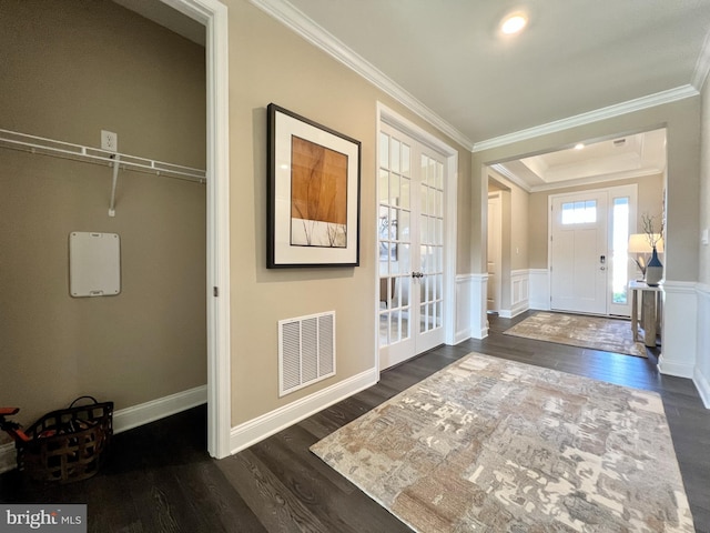 foyer entrance with crown molding, dark hardwood / wood-style floors, and a tray ceiling