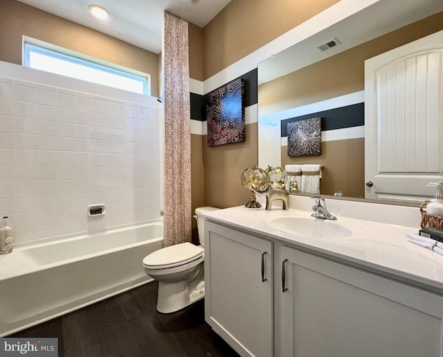 full bathroom featuring vanity, wood-type flooring, shower / tub combo with curtain, and toilet