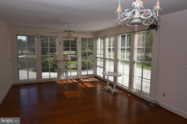 interior space featuring ceiling fan with notable chandelier