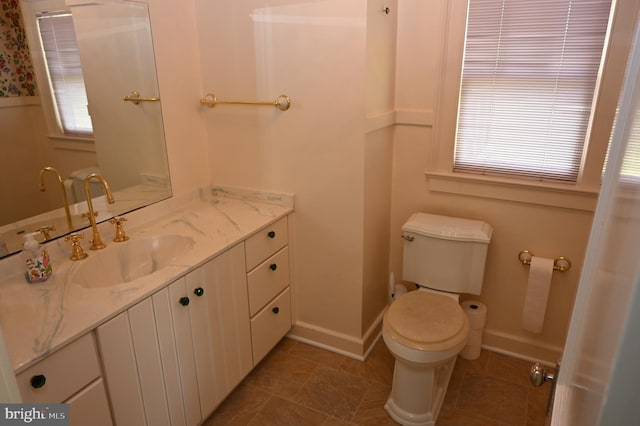 bathroom with vanity, toilet, and a wealth of natural light