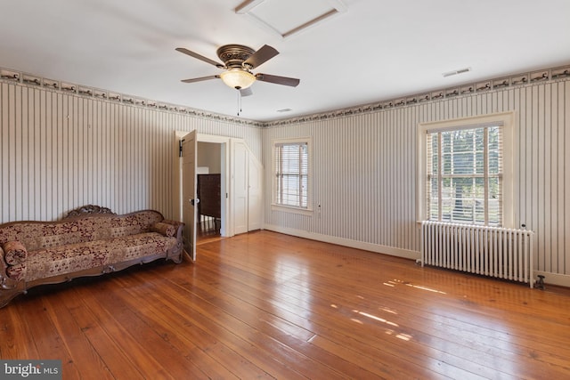 unfurnished living room with radiator heating unit and hardwood / wood-style flooring