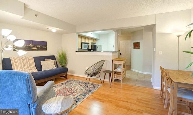 living room featuring a textured ceiling and light wood-type flooring