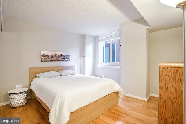 bedroom featuring a textured ceiling and hardwood / wood-style flooring