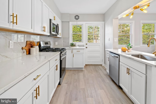 kitchen featuring appliances with stainless steel finishes, white cabinets, and a healthy amount of sunlight