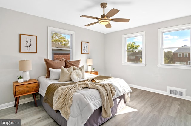 bedroom with light hardwood / wood-style flooring and ceiling fan