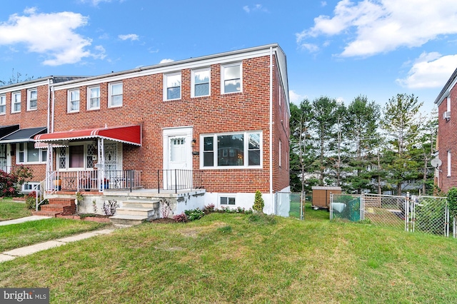 multi unit property with fence, brick siding, and a front yard